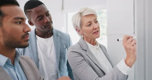 Business Team Collaborating Around Whiteboard in Office