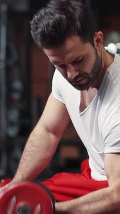 A Man Lifting a Dumbbell in the Gym Emphasizing Fitness Strength Training and Conditioning