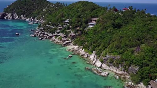 Aerial view at tropical island and the sea. Camera moves forward. Half round panning. Bright sunny d