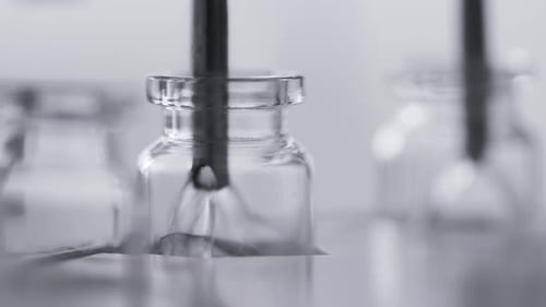 Pharmaceutical medication bottles moving along conveyor belt in pharma factory