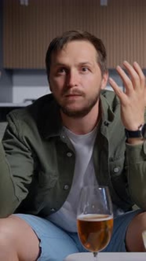A Man in Casual Clothing Enjoys Watching a Football Game in a Cozy Living Room Setting Showing