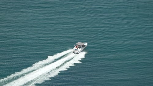 Boat Ocean Water Aerial View A White Motorboat Moves Across the Ocean Leaving a Wake Behind It The