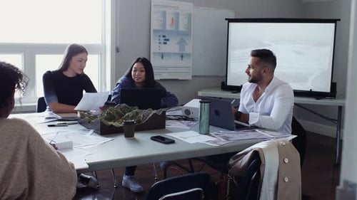 Environmental scientists planning strategy in office meeting with topographic map