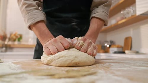 Man Kneading Dough for Baking in Home Kitchen