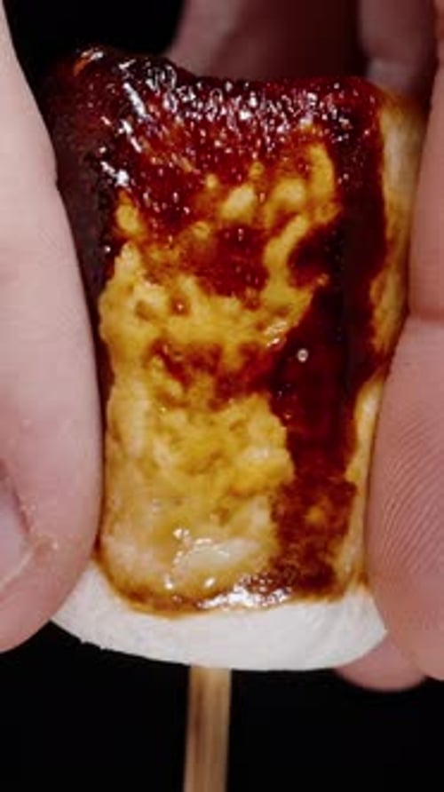Hand Squeezes a Toasted Marshmallow Close Up