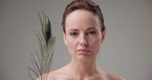 Woman Holding Feather in Studio Fashion Shot