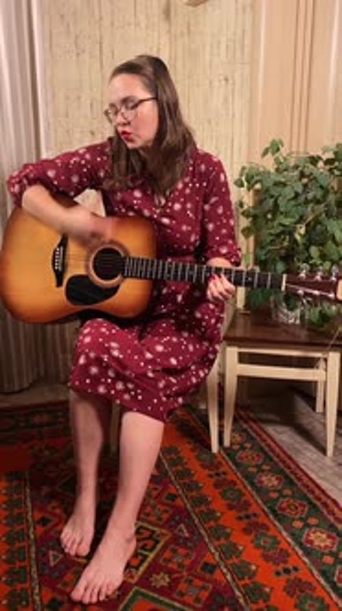 Woman Playing Acoustic Guitar Sitting on Chair