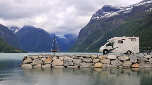 Campervan parked by glacial lake in the mountains