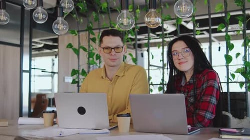 Deux professionnels dévoués s'engagent dans une collaboration productive au sein d'un bureau moderne et élégant