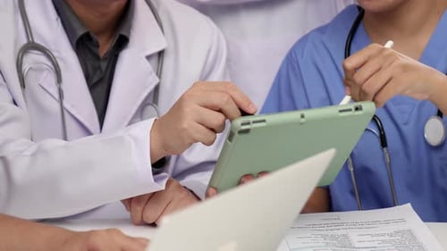 Medical Professionals Reviewing Data on Tablet in Office