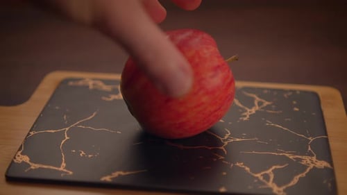 Cutting a Red Apple in Half on Board