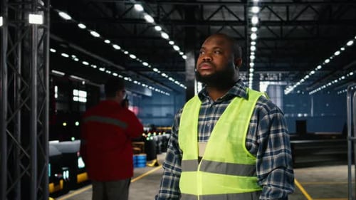 Engineer in Safety Hi Vis Vest Uses Tools in a Fabrication Workshop