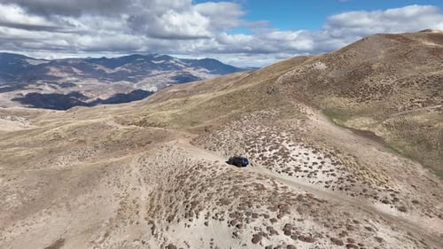 Aerial View Of Offroad Vehicle Climbing Mountain
