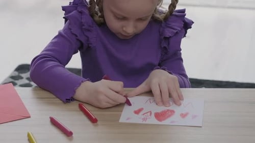 Little Girl is Drawing a Greeting Card for Her Mother with Red Heath Shape Happy Mother's Day