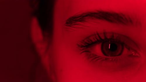 Blinking Red Light On Large Wide Open Girl'S Eye Close Up View