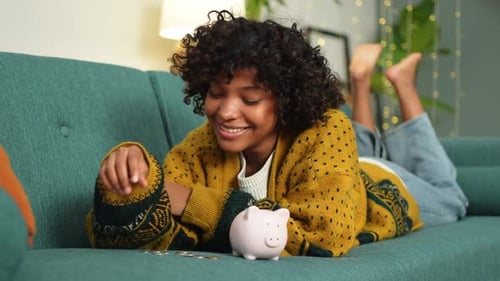 Saving Money Investment for Future African American Girl Putting Money Coin in Pink Piggy Bank