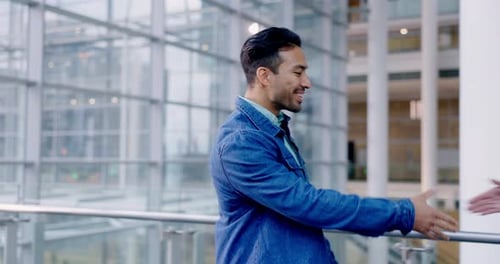 Man Shakes Hands with Woman in Office Building