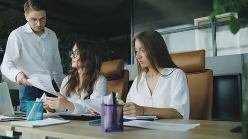 In a Modern Office a Manager Approaches Two Female Employees Who are Socializing Clearly Unhappy