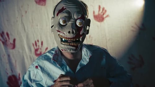 Man Wearing Zombie Mask Buttons Bloody Shirt Indoors