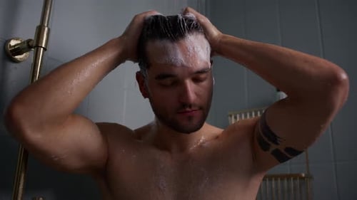 Muscular Man Washing Hair in Shower