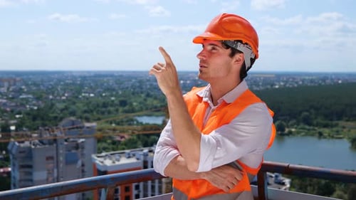 Construction Engineer Pointing Overlooking City Skyline