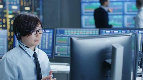 Im Network Operations Center tätigt Trader mit einem Headset einen persönlichen Kundenanruf. Im Hintergrund