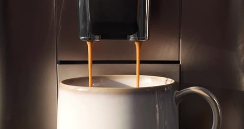 Fresh Espresso Pours into White Ceramic Mug