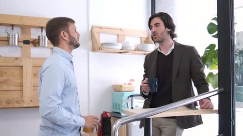 Businessmen in Deep Conversation While Standing in Office Canteen