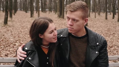 Happy Young Couple in Love Walking in Autumn Park Hugging Kissing and Having Fun