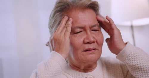 Senior Person Massaging Temples in Pain