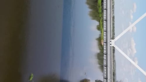Vertikales Video: Die Kamera fliegt unter der Brücke über den Fluss