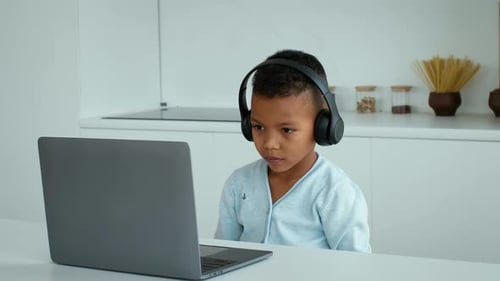 Young Boy Focused on Laptop During Schoolwork at Home