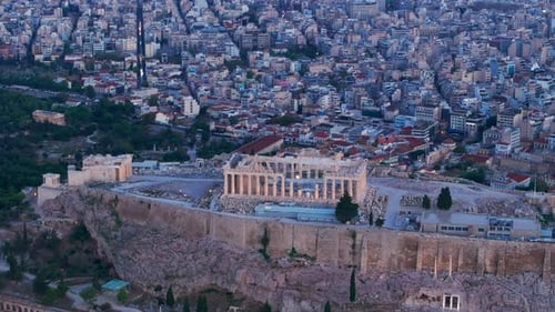 Descending aerial shot of the Acropolis revealing Athens City at dawn