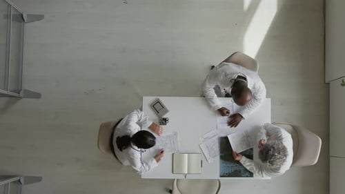 Top View of Diverse Doctors Reading Patient Case Files in Office