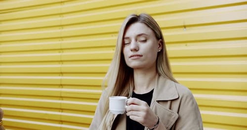 Young Woman Enjoying Coffee on Street