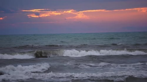 Ocean waves at dusk with fiery clouds above
