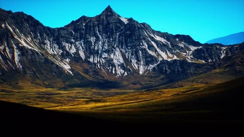 Majestic Mountain Peak Rises Under a Clear Blue Sky at Midday