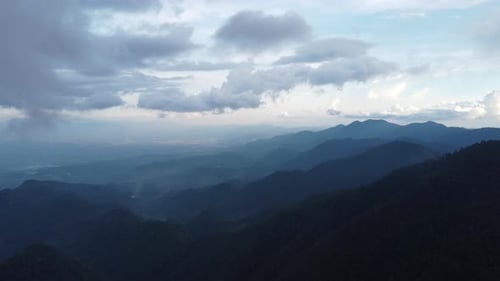 Aerial view of sea of fog on tropical mountains in the early morning. Layers of mountains