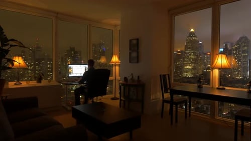 Young Successful Man Living in High Rise City Apartment With Skyline View