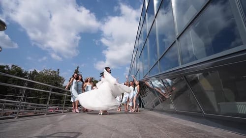 Bride Twirls with Bridesmaids in Urban Setting