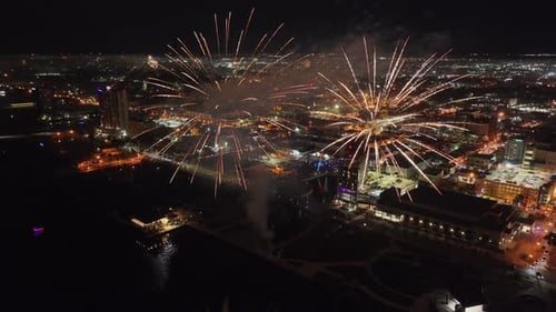 Fireworks burst along Fort Myers coast with illuminated city, Florida in USA. Aerial drone panoramic