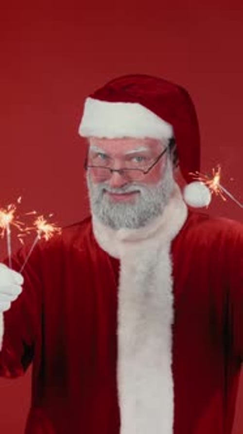 Santa Claus holding sparklers on Red Background