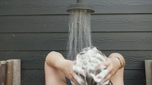 Refreshing outdoor shower with soapy hair wash. Perfect for relaxation and hygiene lifestyle project