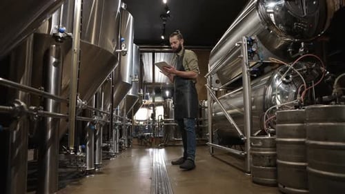 Brewer steuert den Produktionsprozess Bierbrauen Notieren aller Daten Tablet