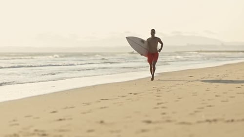 Surfer Running on the Beach with Surfboard