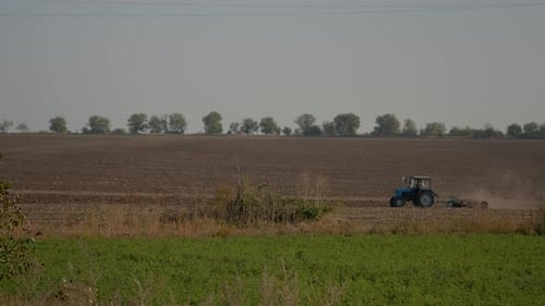 Tractor working hard to prepare land for grain cultivation