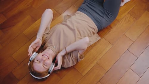 Happy Woman Listening Music With Headphones Lying Down