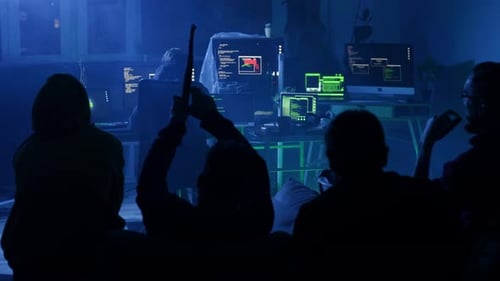 Hackers Gathered Around Computers in a Dark Room