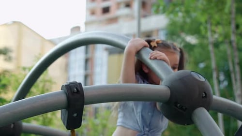 Young Girl Climbs a Playground Structure in a Sunny Park Setting