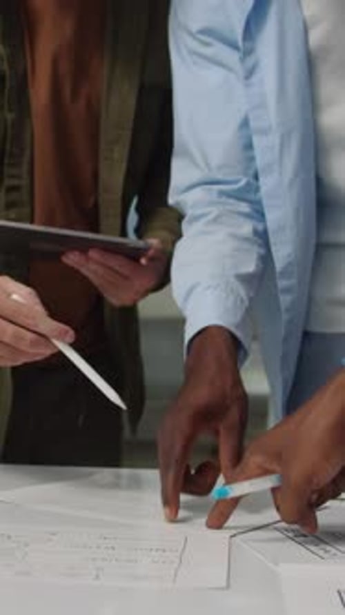 Hands of Engineers Discussing App Interface on paper